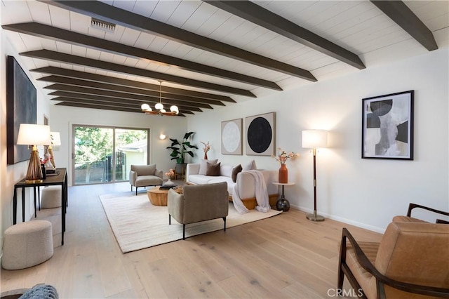 living area featuring light wood finished floors, baseboards, visible vents, beamed ceiling, and a chandelier