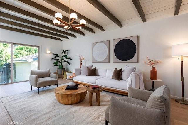 living area featuring a chandelier, beam ceiling, and wood finished floors