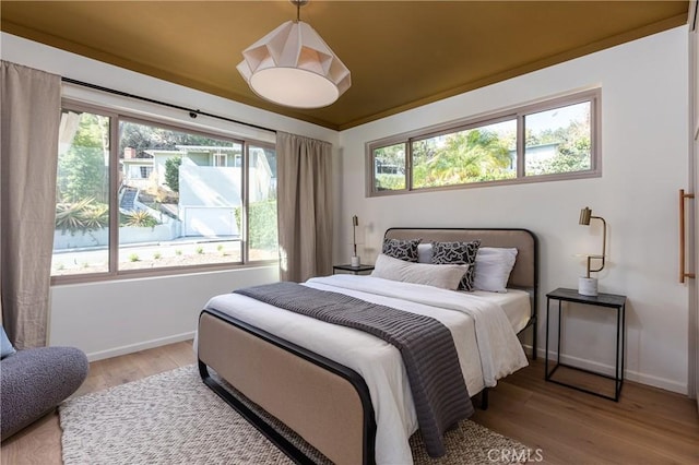 bedroom featuring light wood-type flooring and baseboards