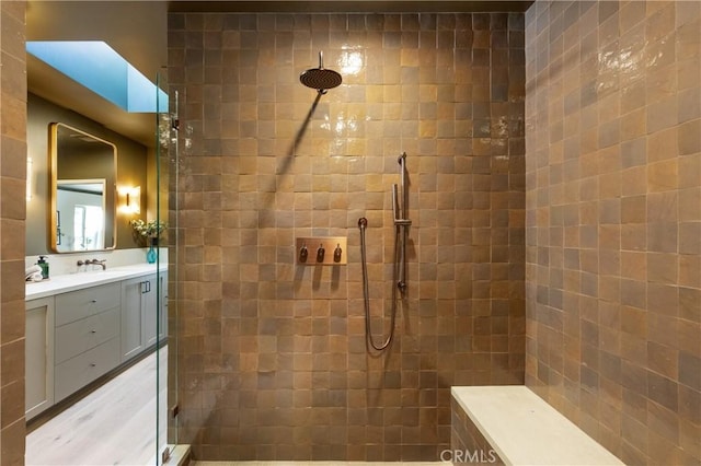 full bath with tiled shower and vanity