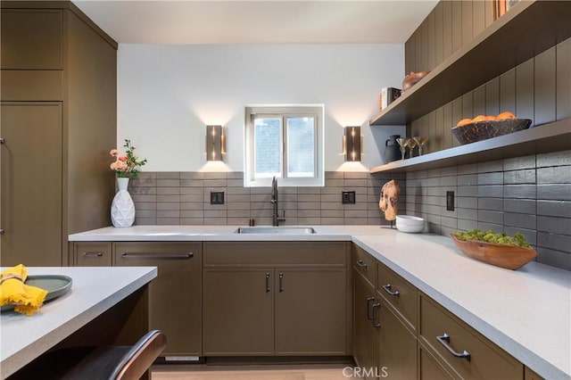 kitchen with tasteful backsplash, light countertops, and a sink