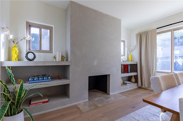 interior space with a fireplace with flush hearth and wood finished floors