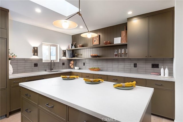 kitchen featuring a skylight, tasteful backsplash, light countertops, open shelves, and a sink