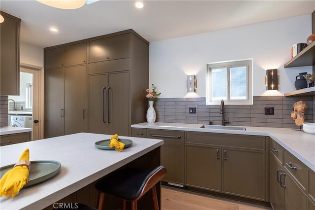 kitchen featuring decorative backsplash, light countertops, open shelves, a sink, and recessed lighting