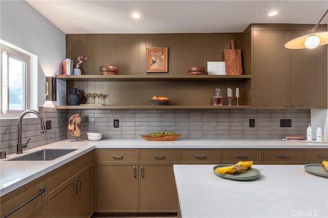 kitchen with tasteful backsplash, open shelves, a sink, and light countertops