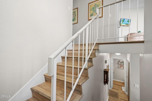 stairway with baseboards and wood finished floors