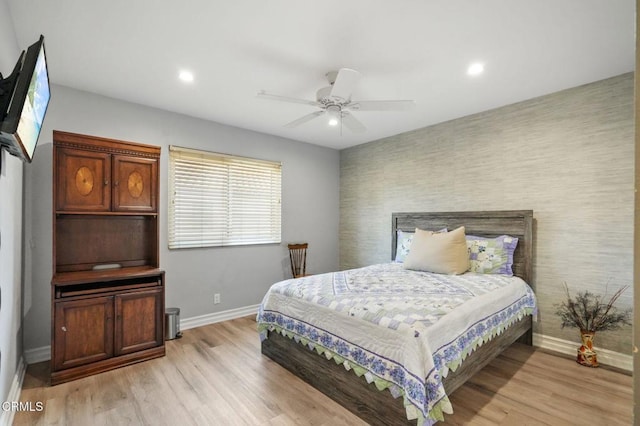 bedroom featuring light wood finished floors, recessed lighting, an accent wall, ceiling fan, and baseboards