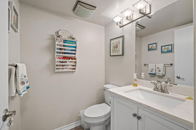 bathroom featuring vanity, toilet, and baseboards