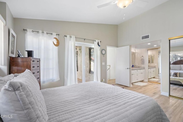 bedroom with visible vents, lofted ceiling, light wood-style flooring, ensuite bathroom, and access to outside