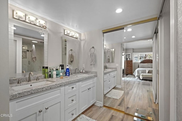 bathroom with double vanity, a sink, and wood finished floors