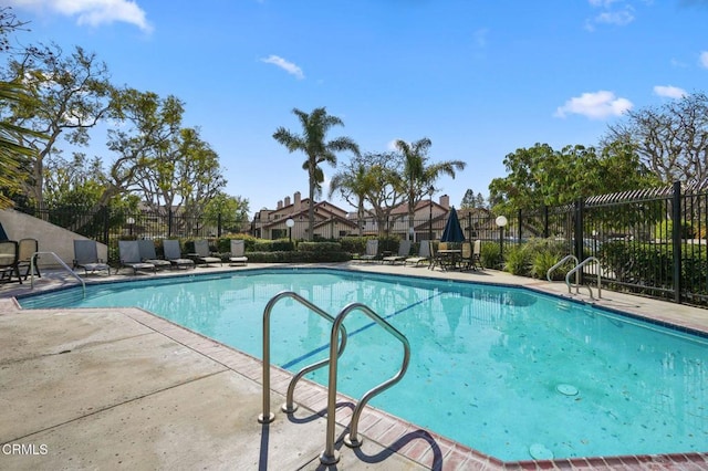 community pool featuring fence and a patio