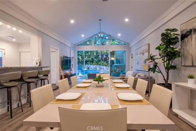 dining area with lofted ceiling, recessed lighting, and wood finished floors