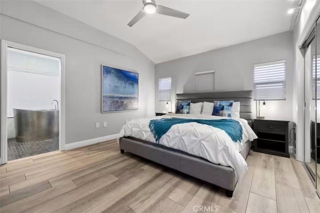 bedroom with lofted ceiling, light wood-type flooring, baseboards, and a ceiling fan