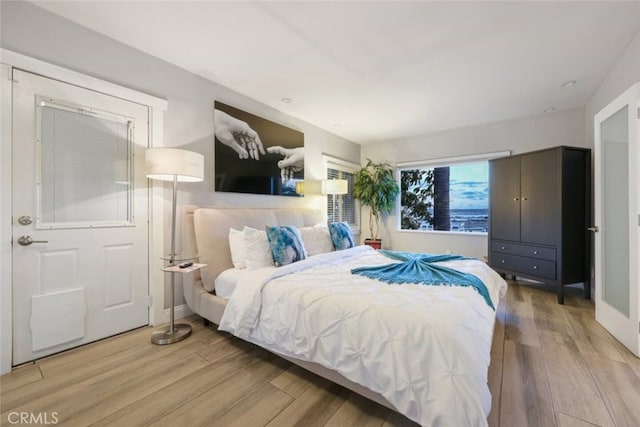 bedroom with light wood finished floors and baseboards