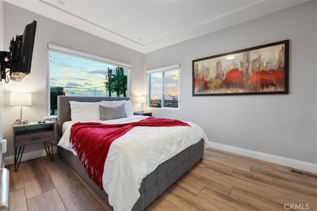 bedroom featuring visible vents, baseboards, and wood finished floors