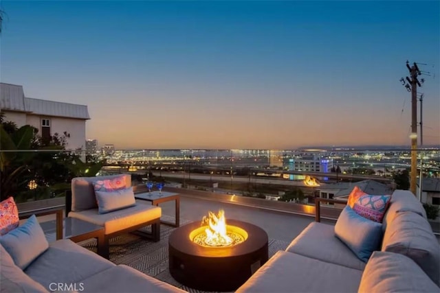 view of patio featuring a city view and an outdoor living space with a fire pit