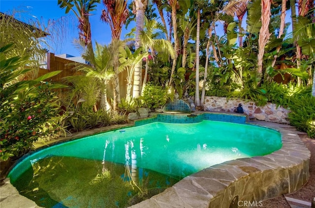 outdoor pool featuring fence