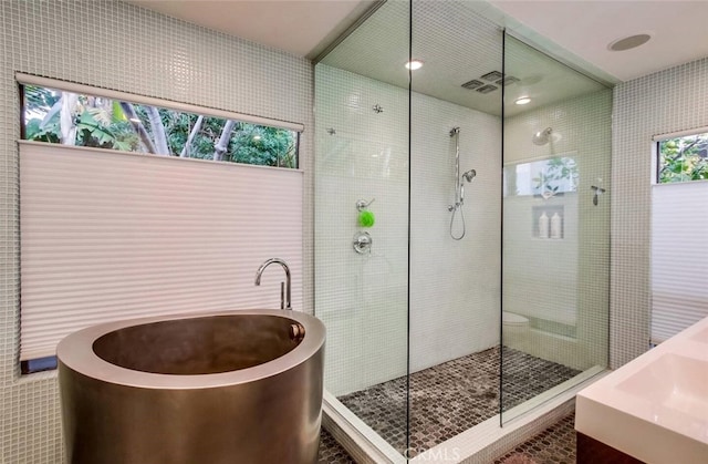 full bath featuring a freestanding bath and walk in shower