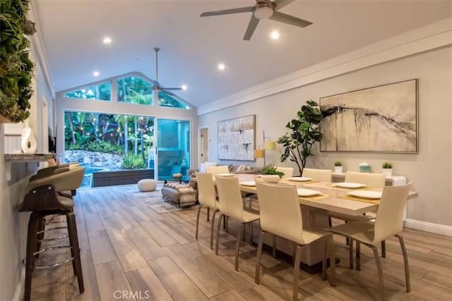 dining area with lofted ceiling, baseboards, a ceiling fan, and wood finished floors