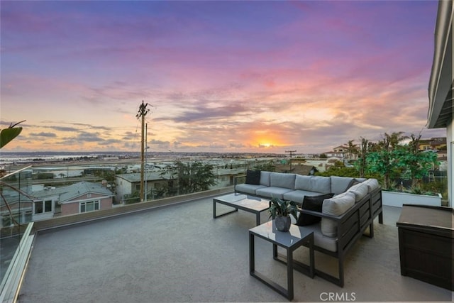 patio terrace at dusk featuring outdoor lounge area and a balcony