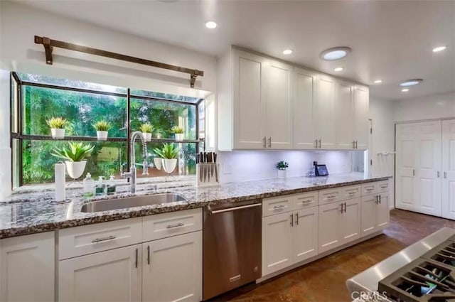 kitchen with white cabinetry, a sink, and stainless steel dishwasher