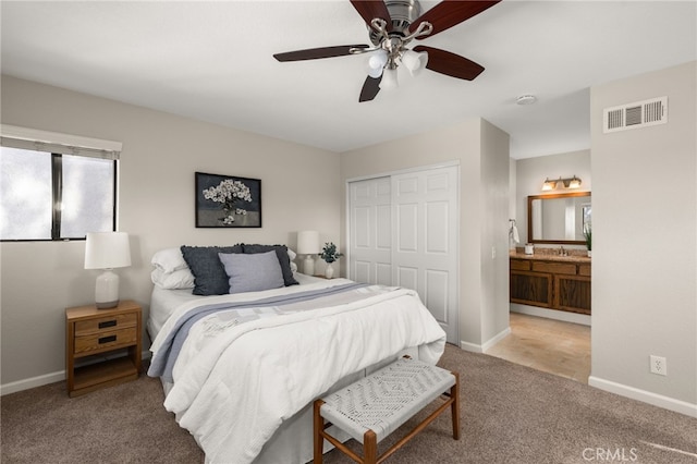 bedroom with baseboards, visible vents, a sink, carpet floors, and a closet