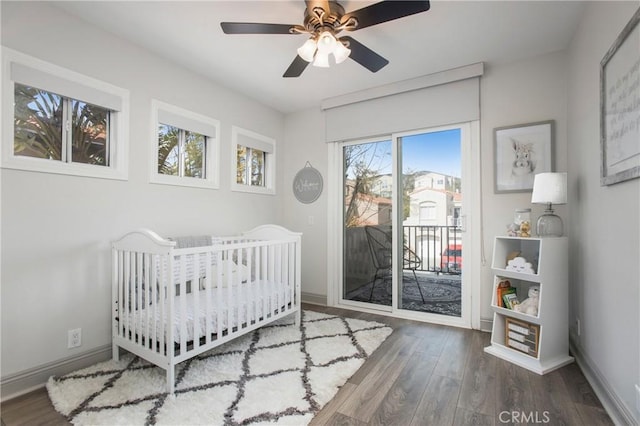 bedroom with baseboards, wood finished floors, and access to exterior