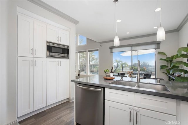 kitchen with plenty of natural light, a sink, white cabinets, appliances with stainless steel finishes, and crown molding