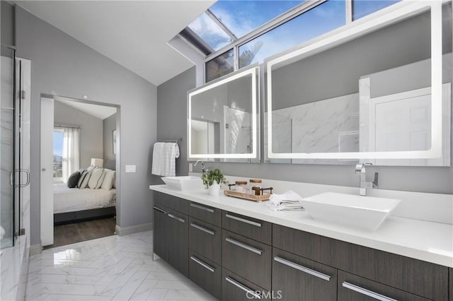 full bath with double vanity, a shower stall, lofted ceiling, and a sink