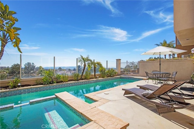 view of pool featuring a pool with connected hot tub, a patio, and fence