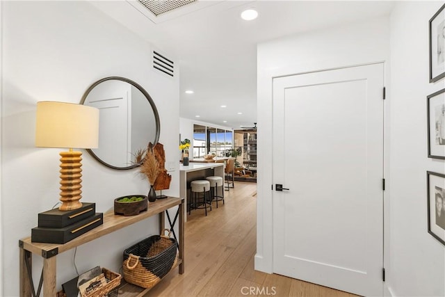 hall featuring recessed lighting, visible vents, and light wood-style flooring