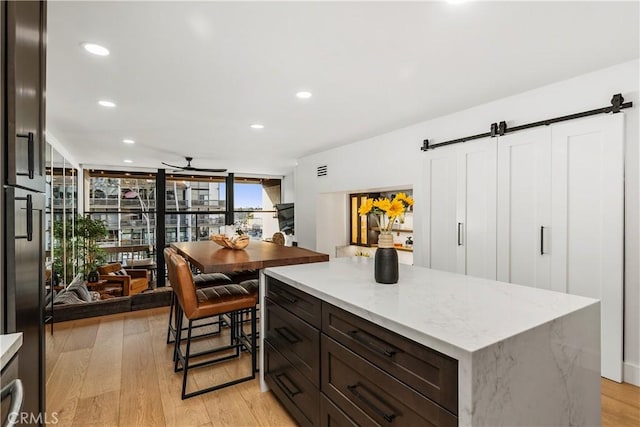 kitchen with expansive windows, ceiling fan, light wood-style flooring, and recessed lighting