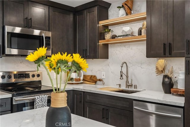 kitchen with decorative backsplash, appliances with stainless steel finishes, dark brown cabinets, and a sink