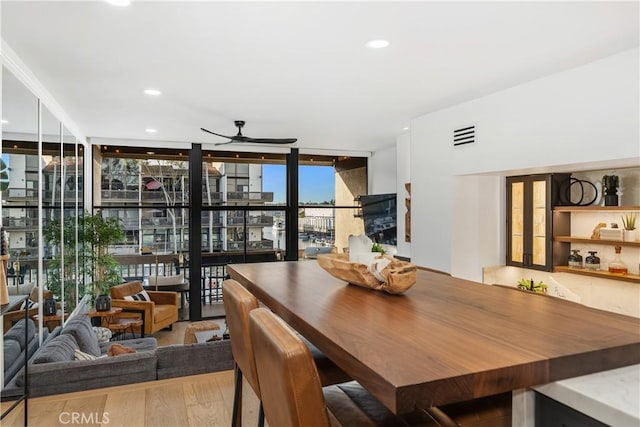 dining area with a wall of windows, recessed lighting, ceiling fan, and wood finished floors