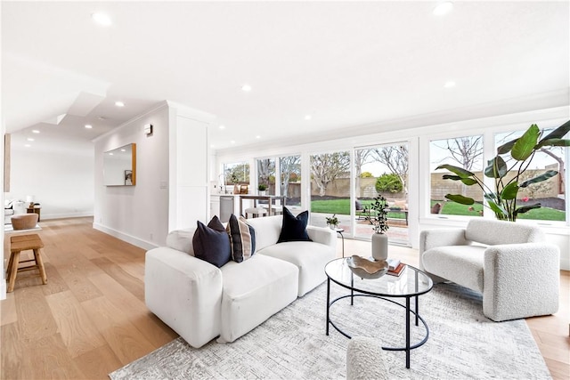 living room with recessed lighting, baseboards, and light wood finished floors