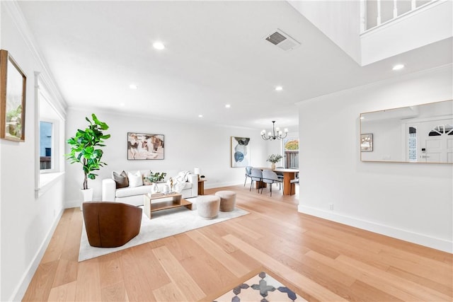 living area with visible vents, ornamental molding, wood finished floors, an inviting chandelier, and recessed lighting