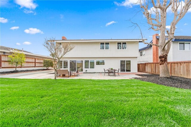 back of house with a yard, a patio area, fence, and stucco siding