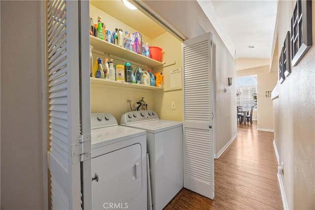 laundry room with laundry area, wood finished floors, independent washer and dryer, and baseboards