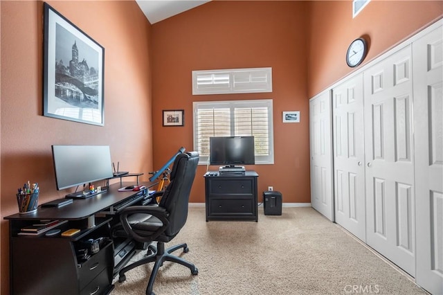 office featuring a high ceiling and baseboards