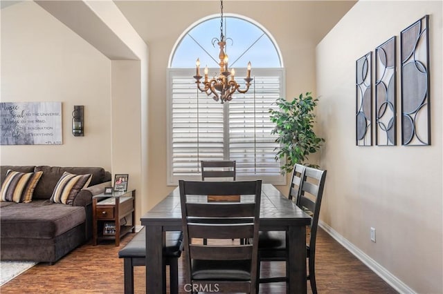 dining area featuring wood finished floors, baseboards, and a chandelier