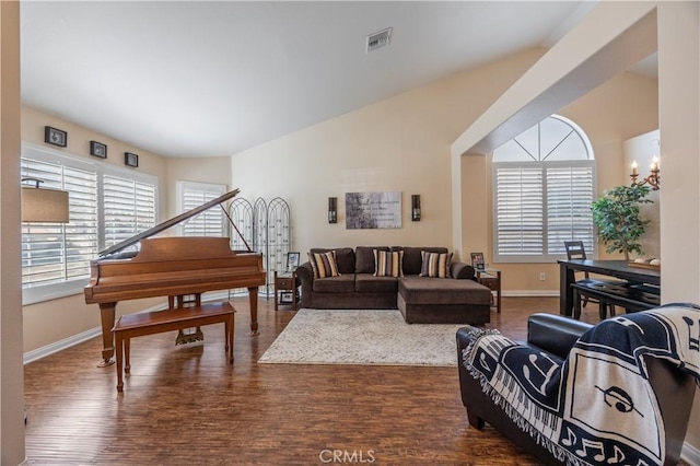 living room with wood finished floors, visible vents, a wealth of natural light, and baseboards