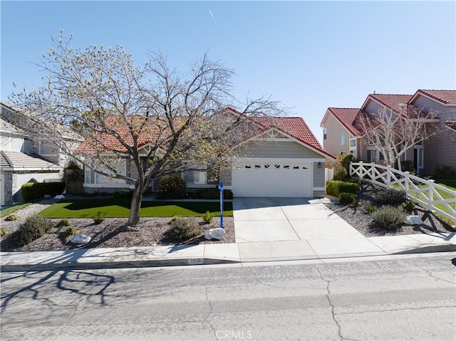 view of front of home with fence, an attached garage, concrete driveway, a front lawn, and a tile roof