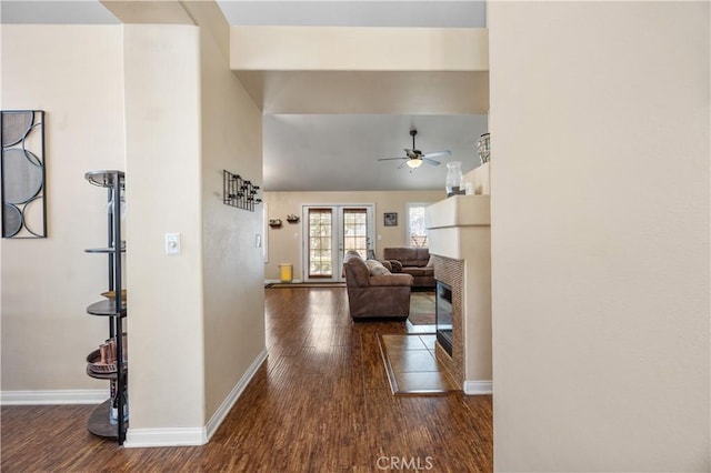 hallway featuring baseboards, lofted ceiling, and wood finished floors