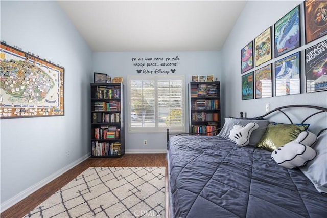 bedroom featuring baseboards, lofted ceiling, and wood finished floors