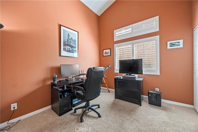 office space featuring carpet flooring, lofted ceiling, and baseboards