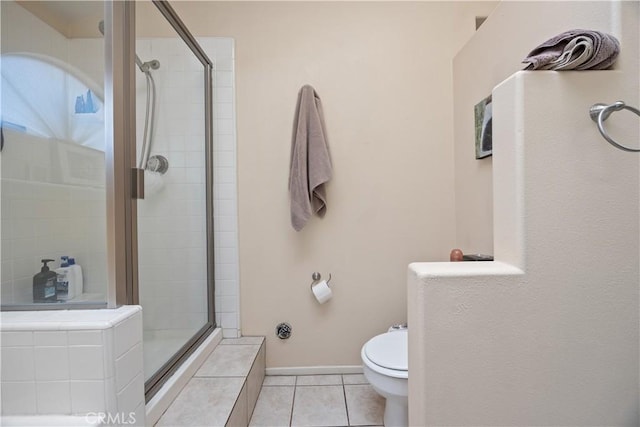 bathroom with tile patterned floors, baseboards, toilet, and a stall shower