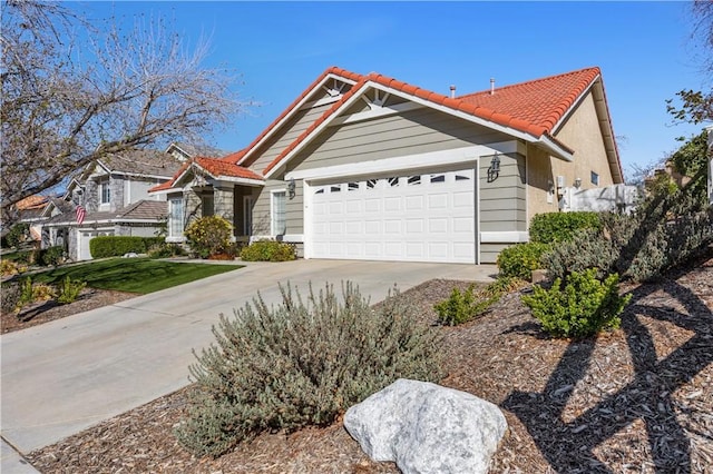 view of front of home featuring a tile roof, an attached garage, and concrete driveway