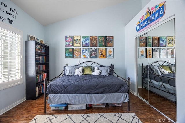 bedroom featuring lofted ceiling, wood finished floors, and baseboards