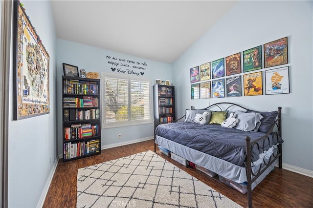 bedroom featuring lofted ceiling, wood finished floors, and baseboards