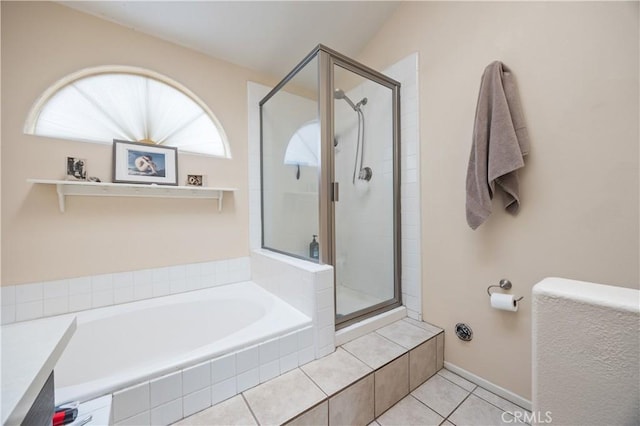 bathroom with a stall shower, tile patterned flooring, and a bath